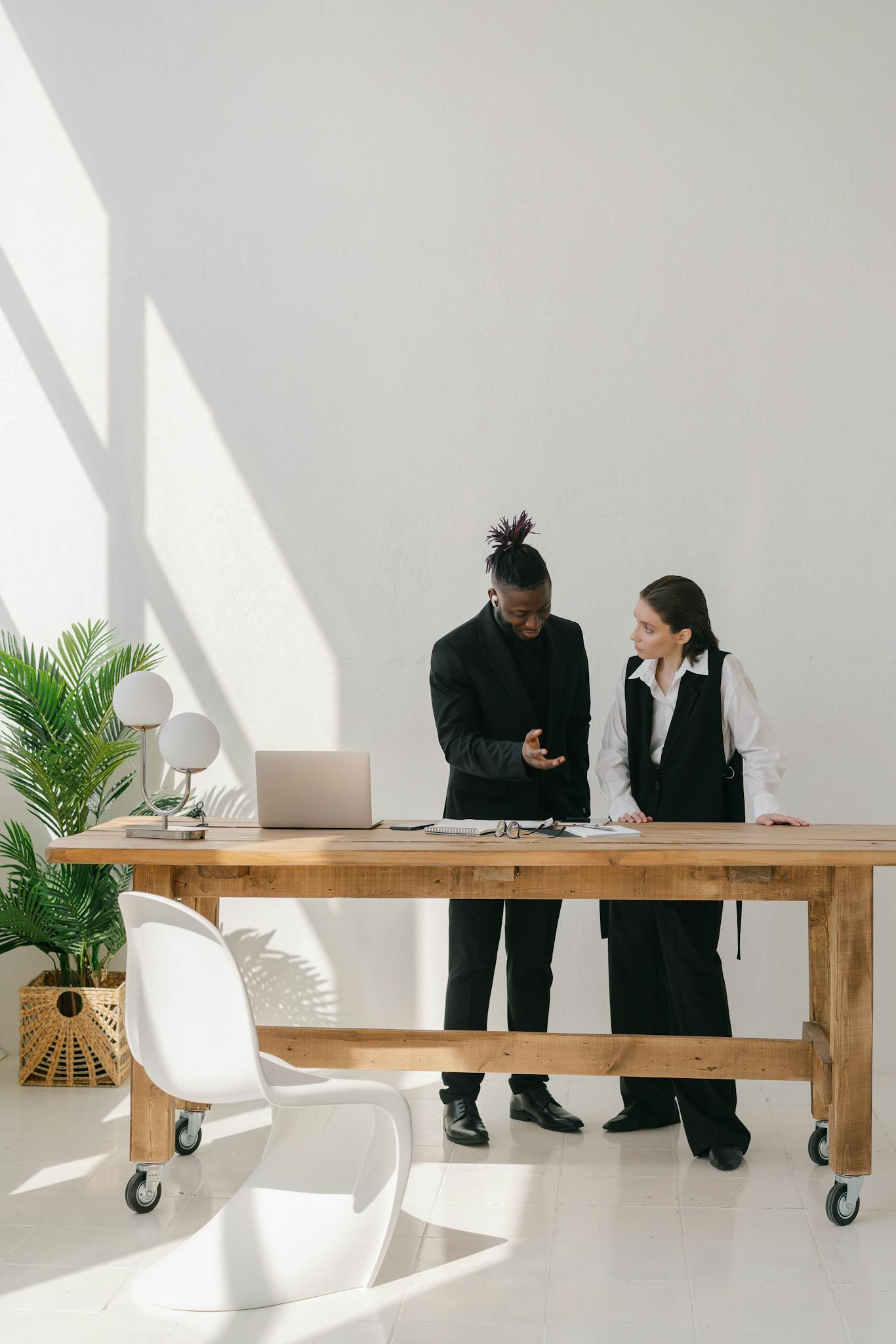 Two professionals engaged in discussion at a sleek office space, showcasing modern business collaboration.